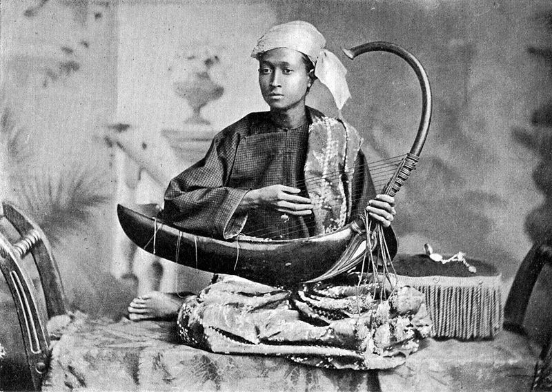 A musician playing an arched harp in Myanmar, possibly 19th century.